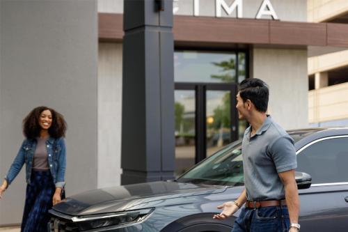 a man and a woman standing next to a car at Hyatt Centric Chicago Ohare in Rosemont