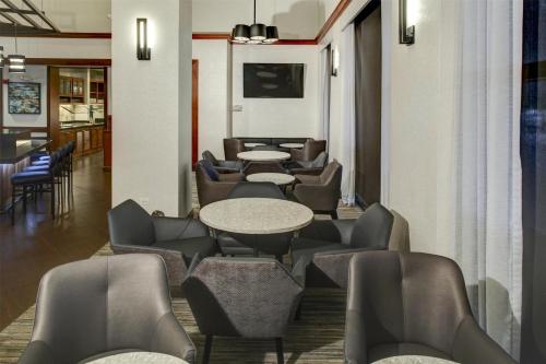 a waiting room with tables and chairs at Hyatt Place Boise/Towne Square in Boise