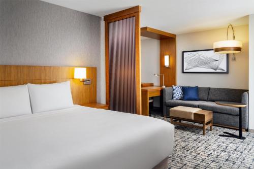 a hotel room with a bed and a couch at Hyatt Place Canton in Lake Cable
