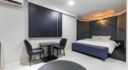a bedroom with a bed and a table and chairs at Hotel Primo Daejeon in Daejeon
