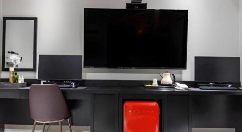 a living room with a large television and two chairs at Hotel Primo Daejeon in Daejeon