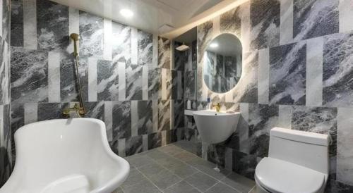 a bathroom with a white toilet and a sink at Hotel Primo Daejeon in Daejeon