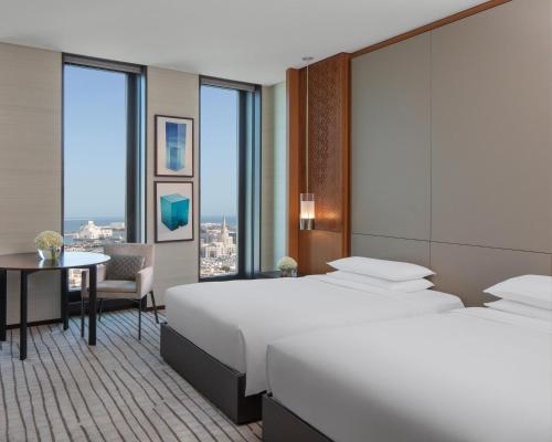 a hotel room with a large bed and a table at Park Hyatt Doha, Msheireb Downtown in Doha