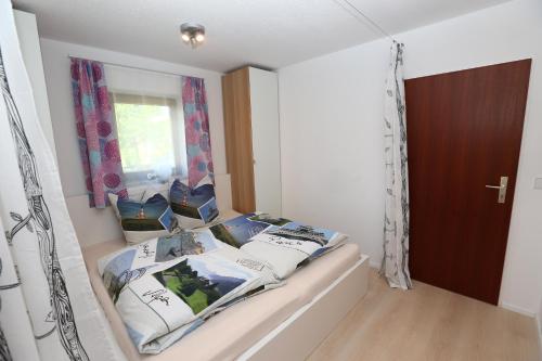 een slaapkamer met een bed met kussens en een raam bij Ferienwohnung Fuchsbau in Peiting