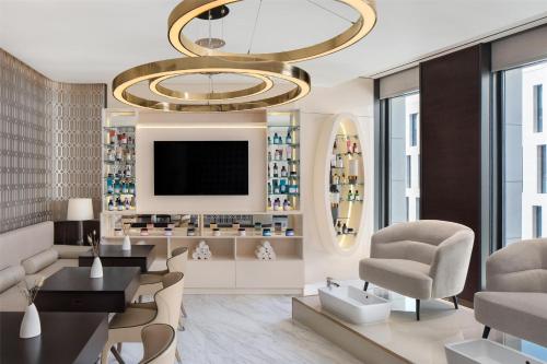 a living room with a tv and a table and a chair at Park Hyatt Doha, Msheireb Downtown in Doha