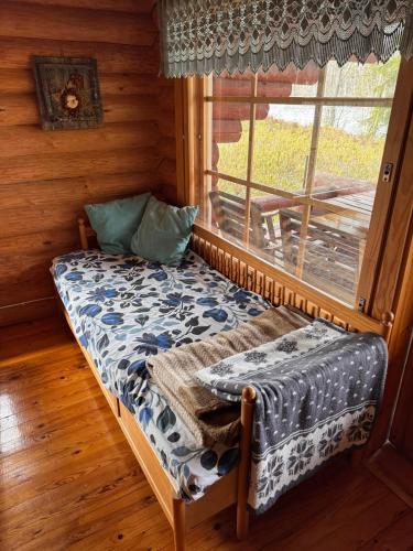 a room with a bench in front of a window at Putkola Cottage Finland in Virasoja