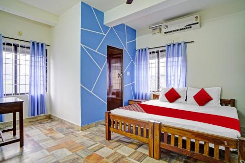 科钦Hotel O Highway Inn的一间卧室设有一张红色和蓝色的墙壁床。