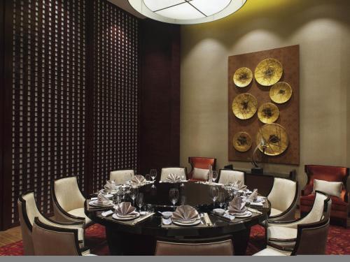 a dining room with a large table and chairs at Movenpick Hotel Enshi in Enshi