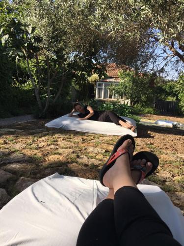 two people laying on beds in the grass at Hemdatya Stone Suites In The Galilee in Ilaniya
