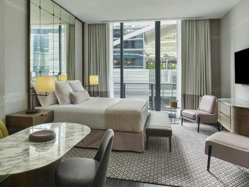 a hotel room with a bed and a table and chairs at SLS LUX Brickell in Miami