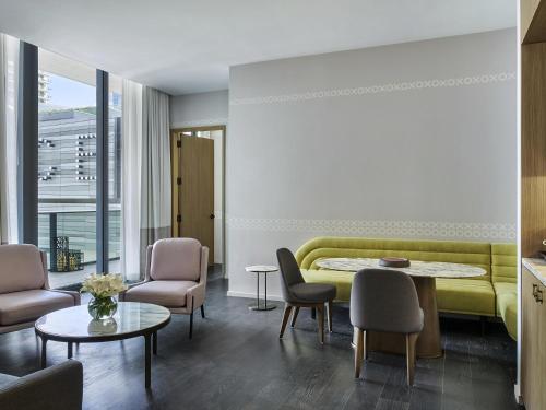 a living room with a yellow couch and chairs at SLS LUX Brickell in Miami