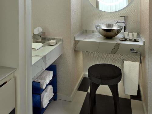 a bathroom with a bowl sink and a stool at Mondrian Los Angeles in Los Angeles