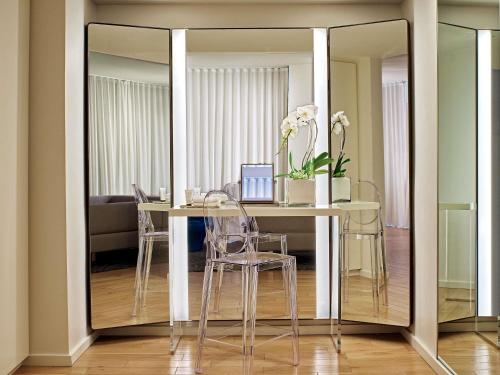 a dining room with a table and a mirror at Mondrian Los Angeles in Los Angeles