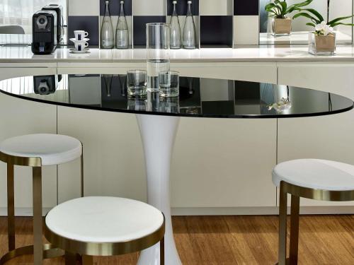 a glass table with two stools in a kitchen at Mondrian Los Angeles in Los Angeles