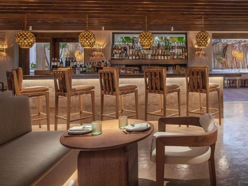 a restaurant with a bar with chairs and a table at Mondrian Los Angeles in Los Angeles