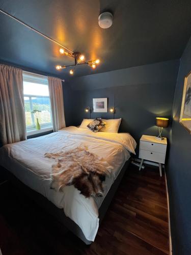 a bedroom with a large bed with a dog laying on it at Cozy familyhouse with free parking & fantastic view in Tromsø