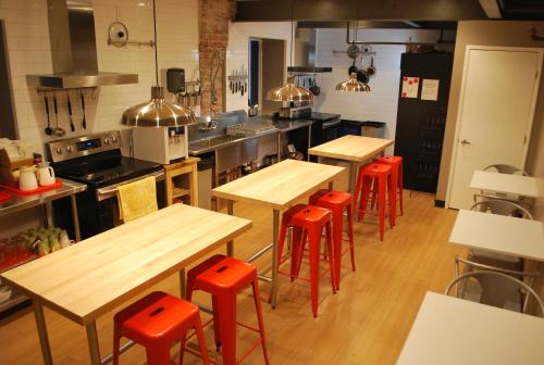a kitchen with wooden tables and red stools at Orange Village Hostel in San Francisco
