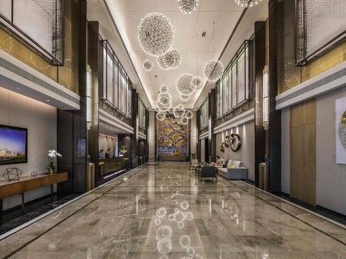 a hallway of a building with a chandelier at Grand Mercure Shanghai Lingang in Shanghai