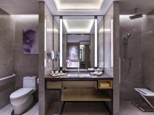 a bathroom with a sink and a toilet and a shower at Grand Mercure Shanghai Lingang in Shanghai