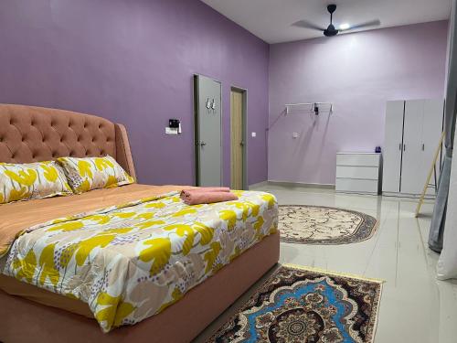 a bedroom with a bed with a yellow and white blanket at Singgah homestay 2 in Sitiawan