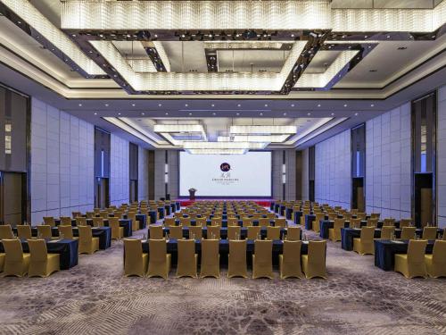 a large room with chairs and a projection screen at Grand Mercure Shanghai Lingang in Shanghai
