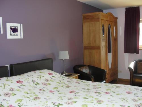 a bedroom with a bed and two chairs and a table at B&B Hedera in Herne