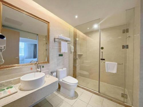 a bathroom with a toilet and a sink and a shower at Vienna Hotel Shenzhen Longgang Baifucheng in Longgang