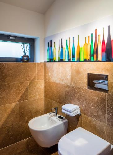 a bathroom with a sink and a toilet and colorful bottles at Loblocher Hof in Neustadt an der Weinstraße