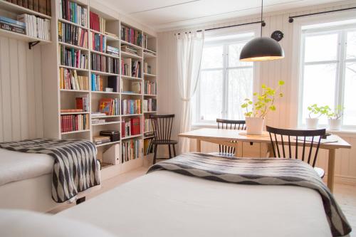 a bedroom with two beds and a book shelf at Åkagårdens Lodge in Båstad