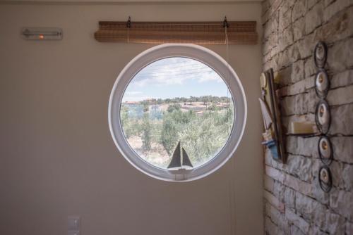 a round window in a room with a view of trees at Villa Tapia in Methoni