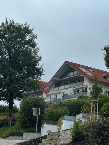 a building with a red roof on a hill at Ferienwohnung Baier in Überlingen