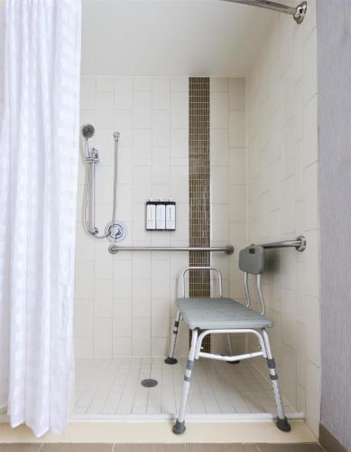 a shower with a chair in a bathroom at Hyatt Place New York Yonkers in Yonkers