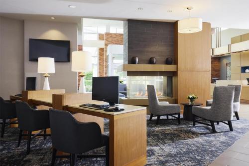 a lobby with a desk with a computer and chairs at Hyatt Place New York Yonkers in Yonkers
