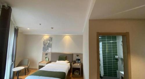 a hotel room with a bed and a bathroom at GreenTree Inn Xuzhou High Speed Railway Station Express Hotel in Xuzhou