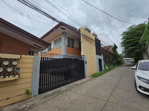 a house with a fence and a car parked next to it at Ciello Accomodation in Cagayan de Oro
