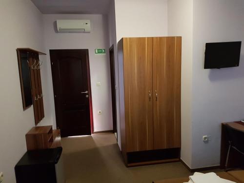 a room with a door and a wooden cabinet at Hostel Kristal in Vinkovci