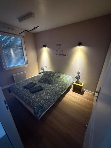 a bedroom with a bed and a sign on the wall at Rozenhof - Appartement au coeur d'Armentieres in Armentières