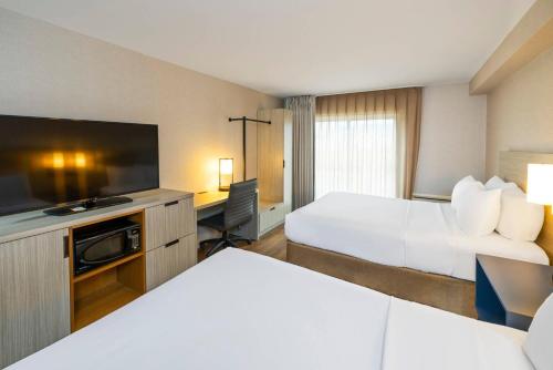 a hotel room with two beds and a flat screen tv at Comfort Inn in Truro