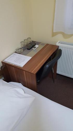 a wooden desk with a chair next to a bed at Hostel Kristal in Vinkovci