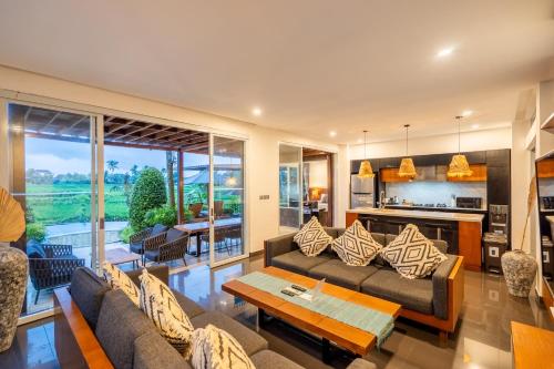 a living room with a couch and a table at Coconut Grove Villa by Betterplace in Ubud