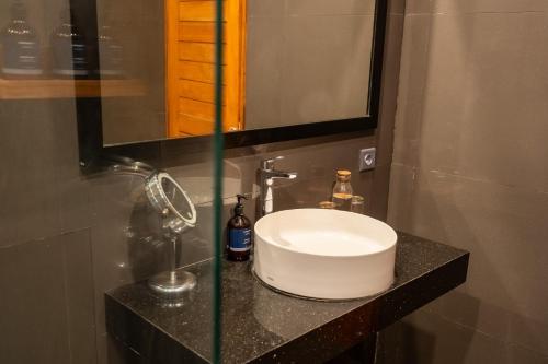 a bathroom with a sink and a mirror at Coconut Grove Villa by Betterplace in Ubud