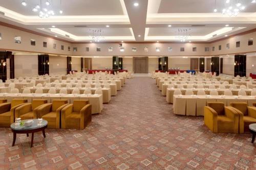 a large banquet hall with rows of tables and chairs at Hotel Pangeran in Pekanbaru