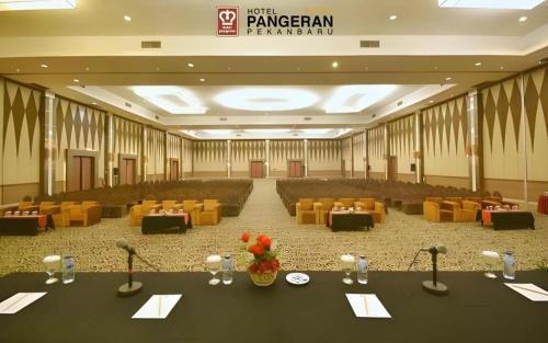 a large banquet hall with tables and yellow chairs at Hotel Pangeran in Pekanbaru