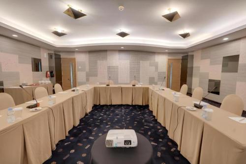 a large room with rows of tables and chairs at Hotel Pangeran in Pekanbaru