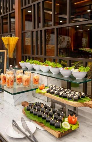 a buffet with sushi and other food on display at Hotel Pangeran in Pekanbaru