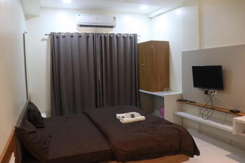 a small bedroom with a bed and a television at Hotel Mayur Residency in Ellora