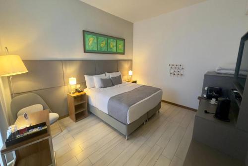 a hotel room with a bed and a chair at Dazzler by Wyndham Ciudad del Este in Ciudad del Este