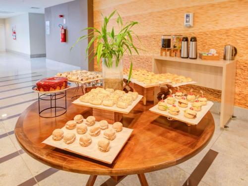 a bunch of pastries on trays on a table at Mercure Rio de Janeiro Barra da Tijuca in Rio de Janeiro