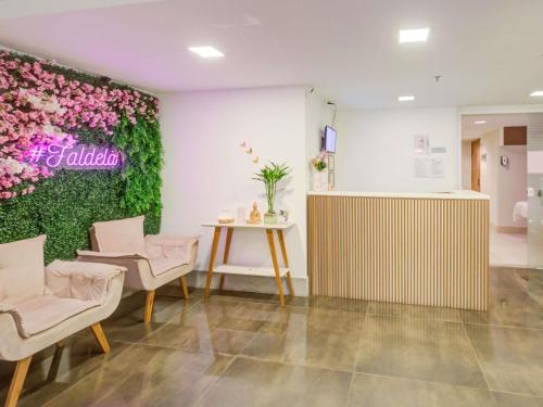 a room with a flower wall with a table and chairs at Mercure Rio de Janeiro Barra da Tijuca in Rio de Janeiro