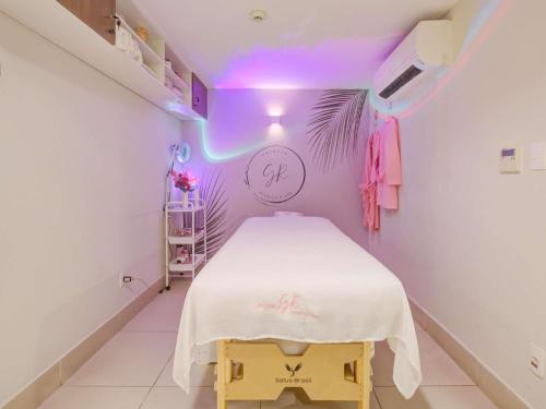 a small room with a bed with a purple ceiling at Mercure Rio de Janeiro Barra da Tijuca in Rio de Janeiro